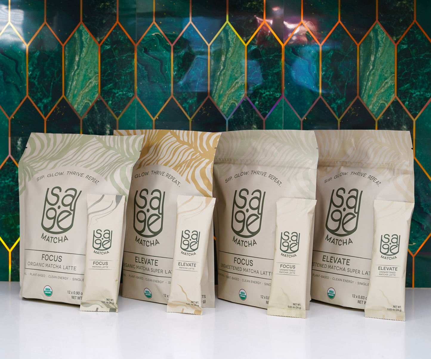 Four varieties of pouches and single serving sticks of Sage Matcha propped up in front of emerald green wallpaper.