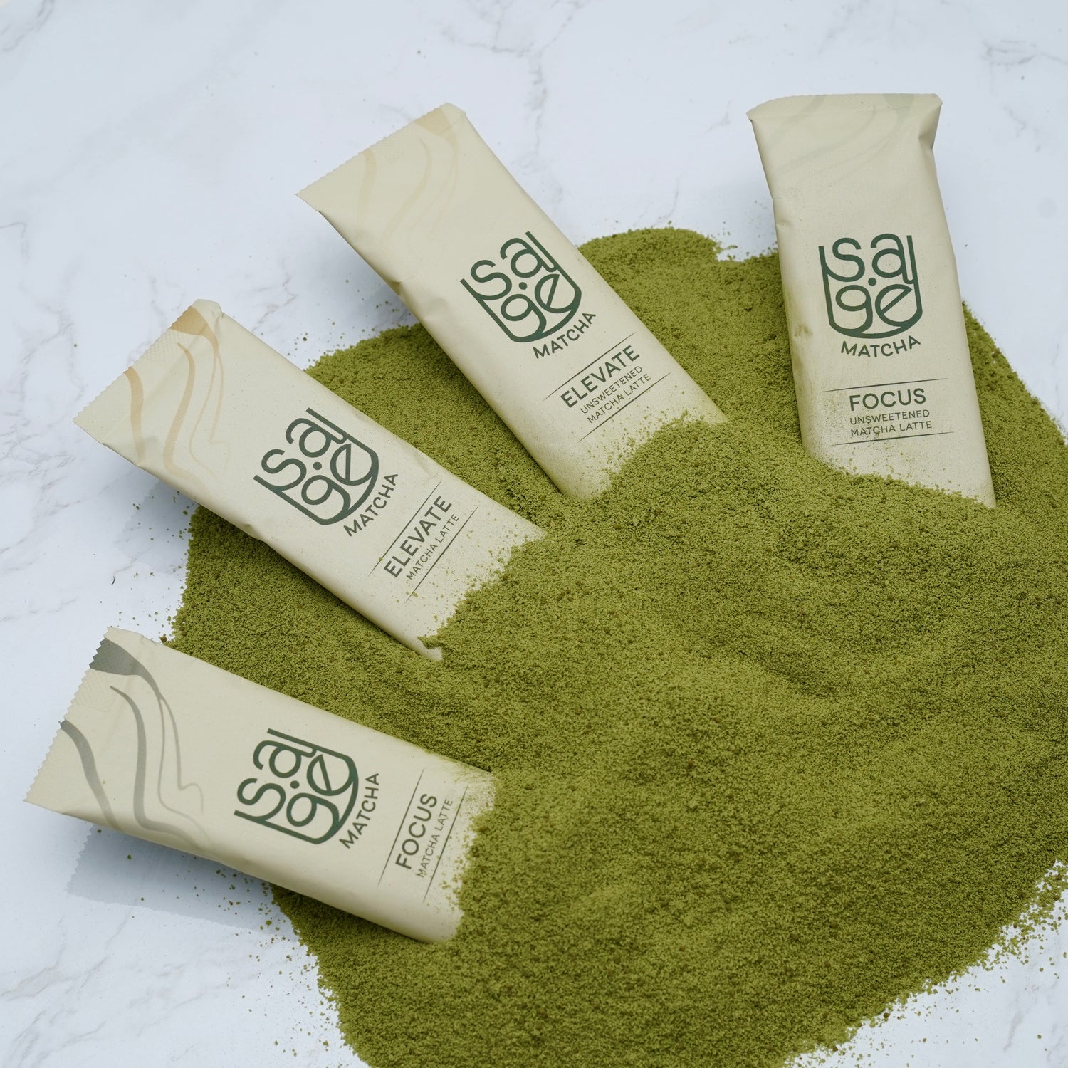 4 Varieties Sage Matcha Single Serving Instant Latte Sticks, laid on top of Sage Matcha powder, on marble countertop.